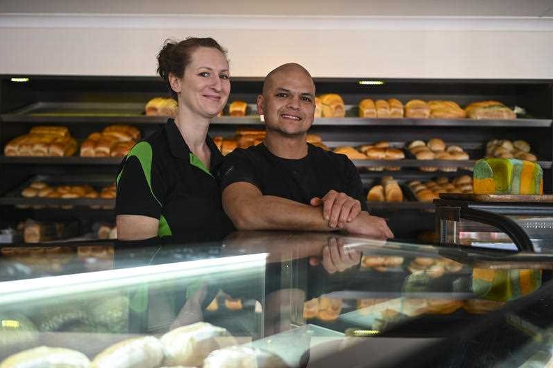 A couple smiling in a bakery.