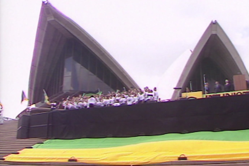 Green and yellow material lies across the Sydney Opera House steps.