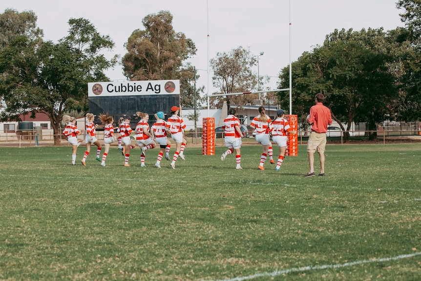 The women's rugby union side doing high knees during training.