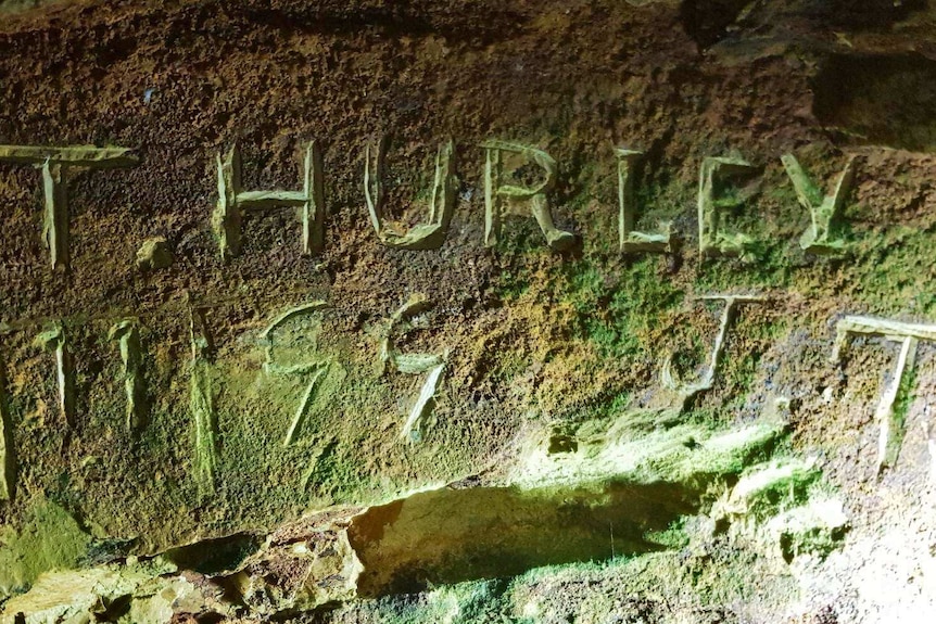 engraving on gold tunnel wall reading T.Hurley