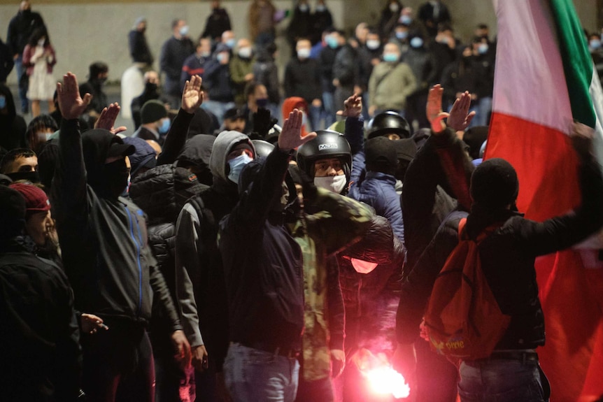 People gathered shout slogans during an evening street  protest.