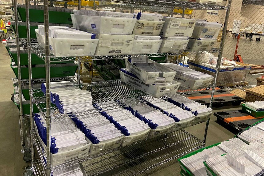 A shelf filled with envelopes in US Postal Service boxes