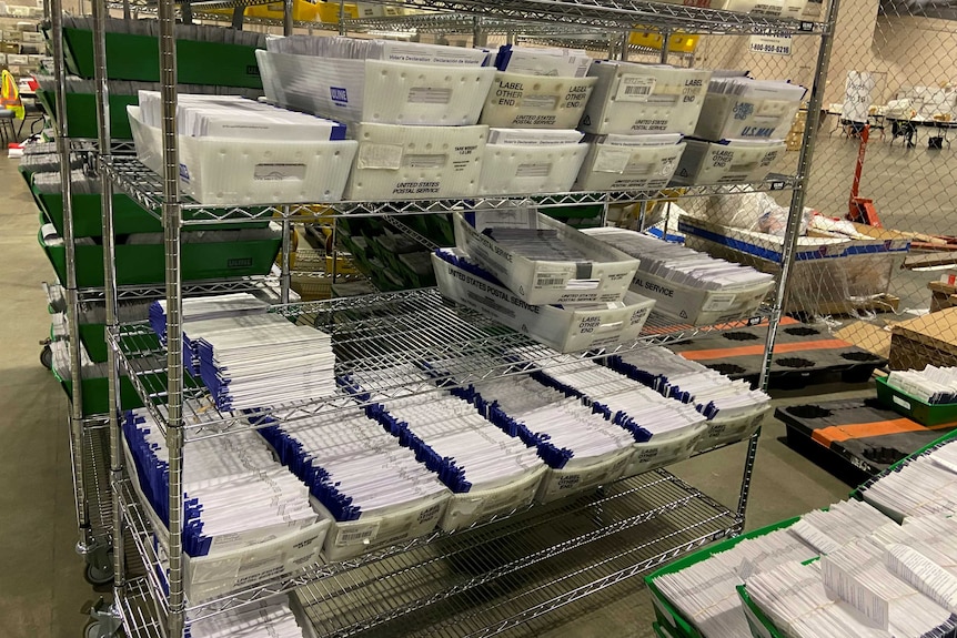 A shelf filled with envelopes in US Postal Service boxes