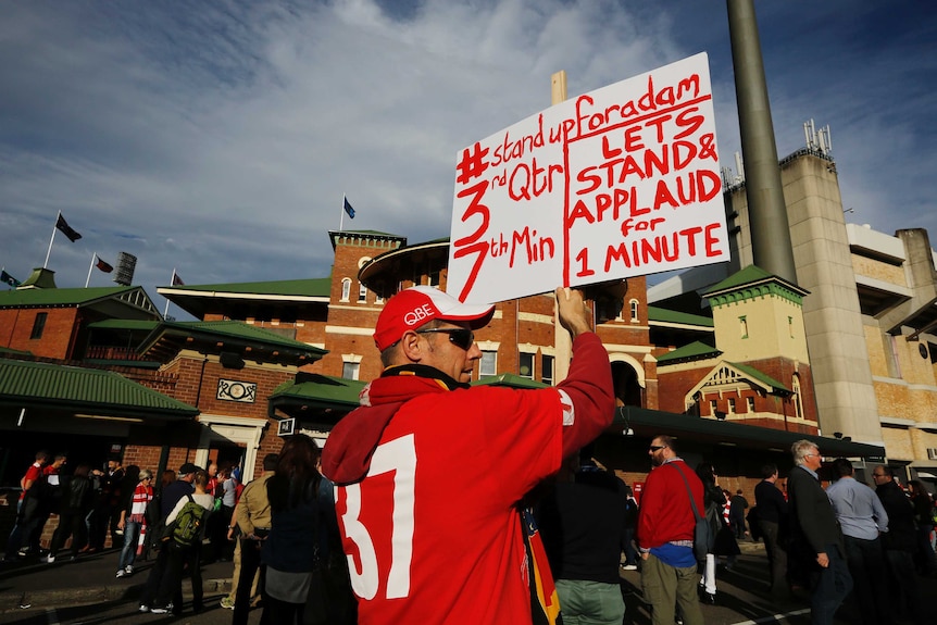 Swans fan holds banner for Goodes