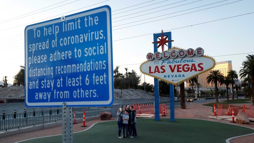 A family takes a selfie at the normally crowded "Welcome to Las Vegas" sign.