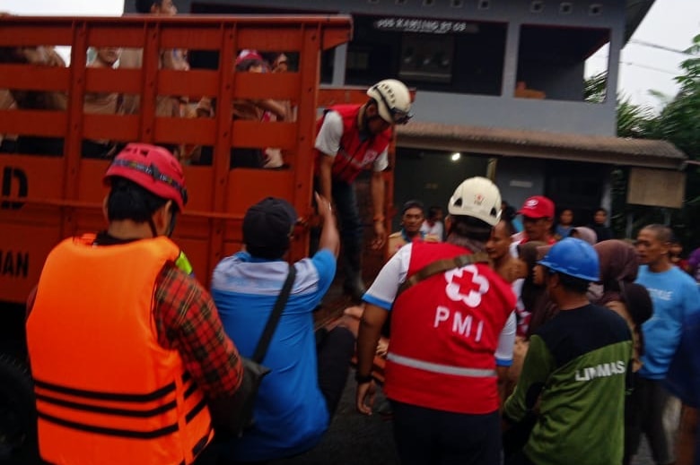 Students are helped down from the back of a truck by rescue workers.