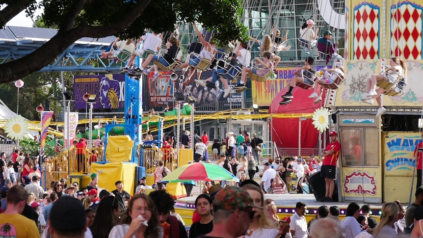 a wide shot of people and rides in sideshow alley