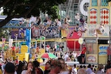 a wide shot of people and rides in sideshow alley