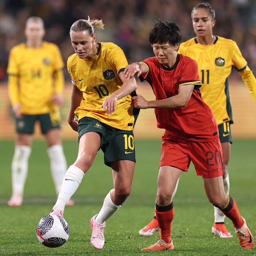 Emily Van Egmond of Australia and Zhang Rui of China compete for the ball
