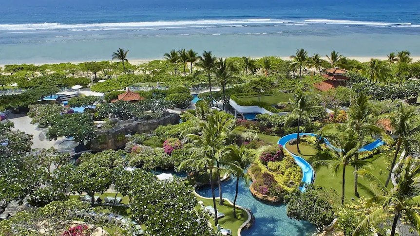 An aerial view of the Grant Hyatt resort shows luxurious buildings and pools nestled in lush green surrounds