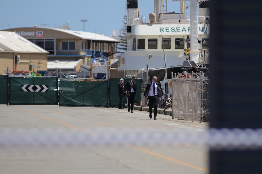 Detectives in a harbour with crime scene tape