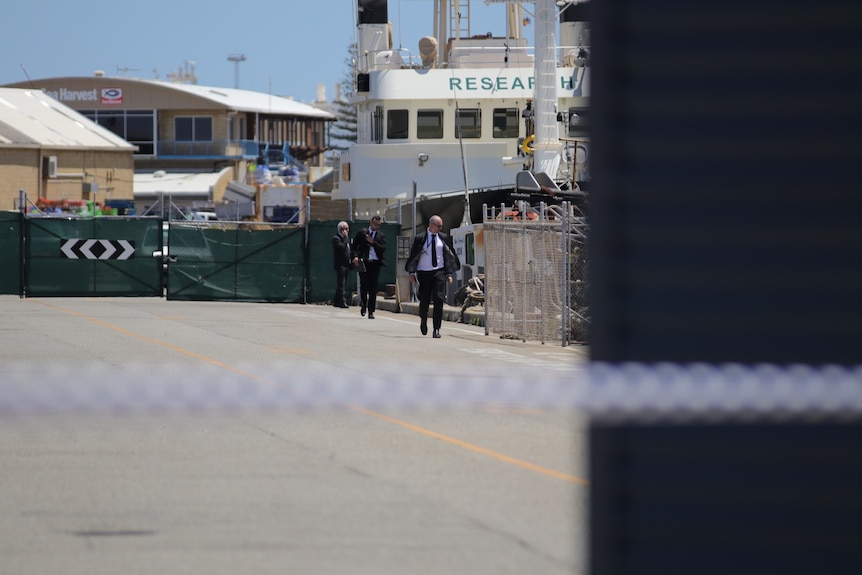 Detectives in a harbour with crime scene tape