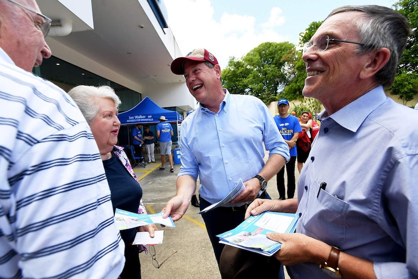 Queensland Opposition leader Tim Nicholls (centre) with LNP MP Ian Walker (right) hand out how-to-vote cards in Upper Mt Gravatt