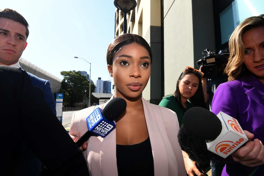 Haja Timbo is surrounded by reporters as she arrives at court.