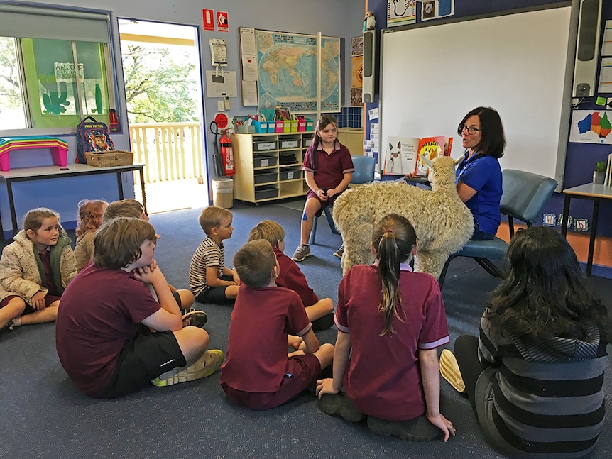 Michelle Malt reads to school students.