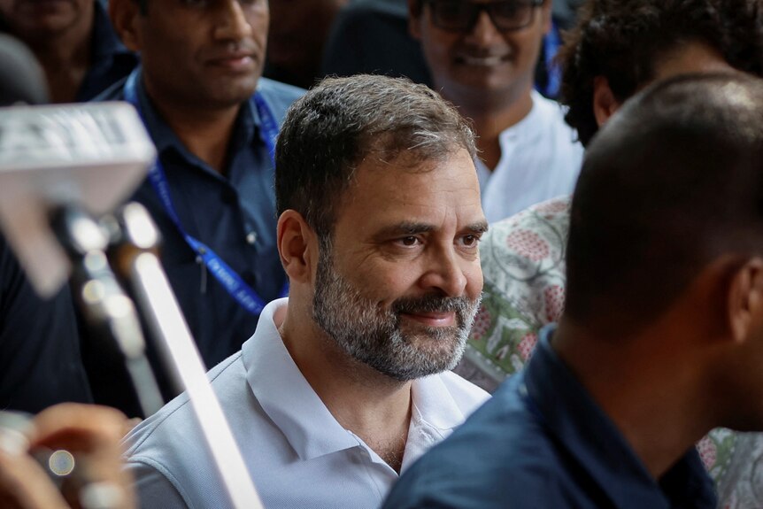 Indian politician Rahul Gandhi with salt and pepper facial hair surrounded by people 