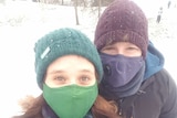 Sarah and Jackson wearing masks in the snow.
