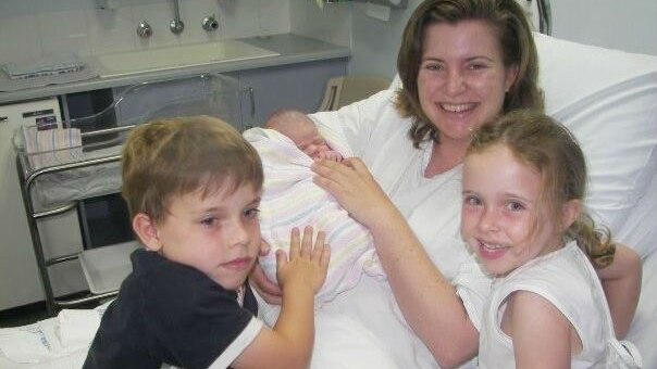 Toni McCaffery nurses new-born baby Dana, who later died of whooping cough, as her two older children look on.