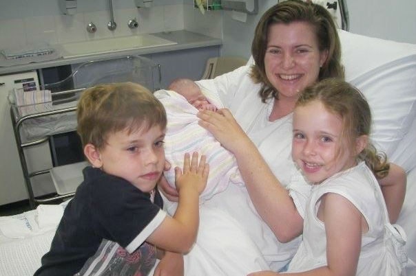 Toni McCaffery nurses new-born baby Dana, who later died of whooping cough, as her two older children look on.