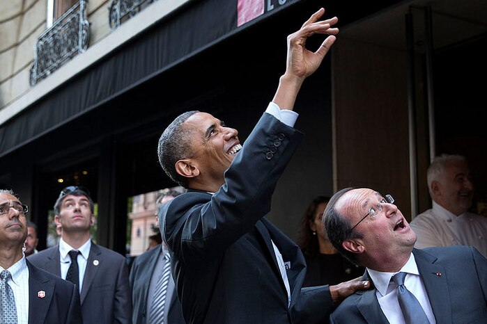 Barack Obama and Francois Hollande look up and wave