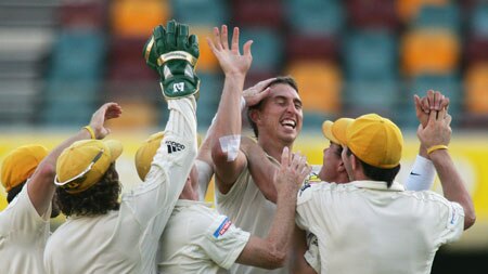 Brett Dorey is mobbed by his Warriors team-mates after taking one of his seven wickets against Qld