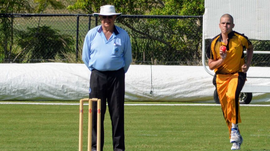 Cooper prepares to bowl on a cricket pitch