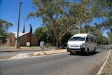 A maxi taxi drives by a Lutheran Church on Gap Road.