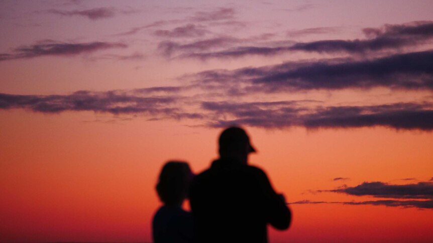 silhouette of couple watching a sunrise
