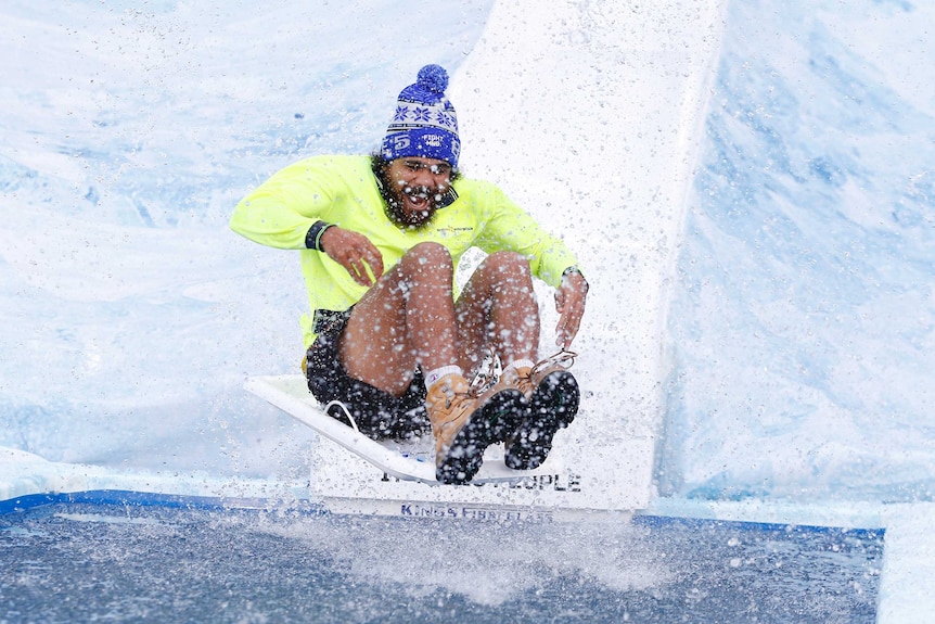 Cyril Rioli mid-air on a slide above a pool of icy water at Big Freeze 5 at the MCG.