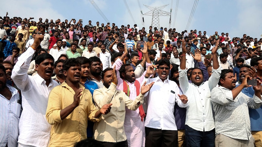 People shout slogans in favour of police and cheer them four the fatal shooting of the rape accused.