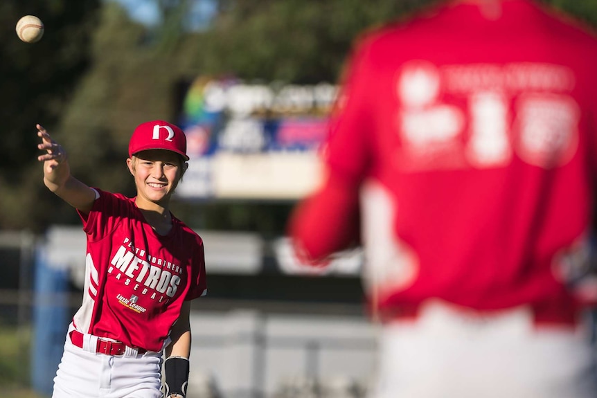 Jordan Strohfeld plays little league baseball throws the ball.