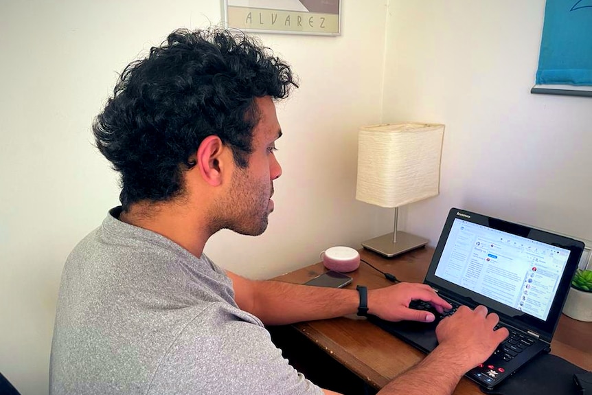 A university student working at a laptop.