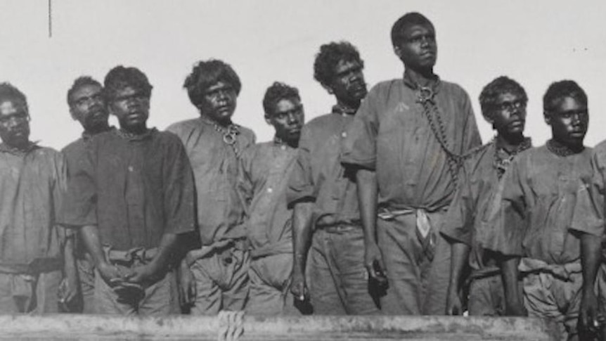 Old photo of Aboriginal men with chains around their necks