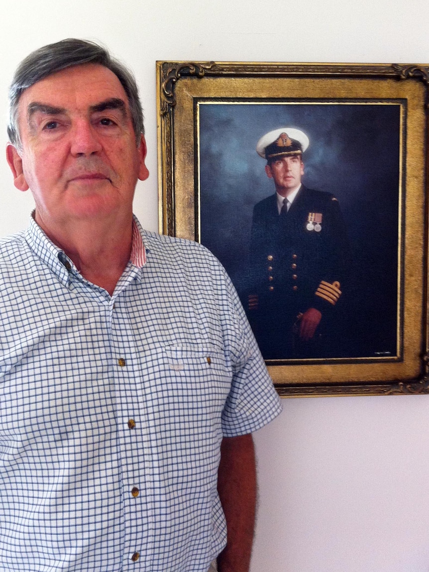 John Ingram poses next to his official portrait.