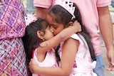 Two young girls hug