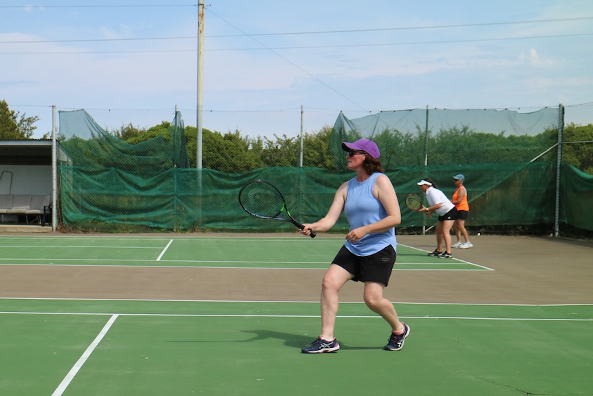 A couple of women playing tennis on two courts