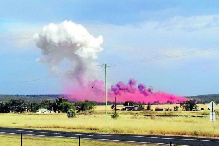 A pic and white plume of smoke can be seen in a vast grass paddock