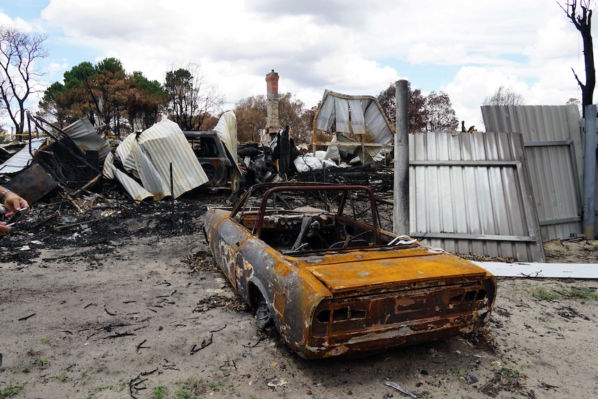 Burnt out car and buildings in the bushfire devastated town of Yarloop in WA