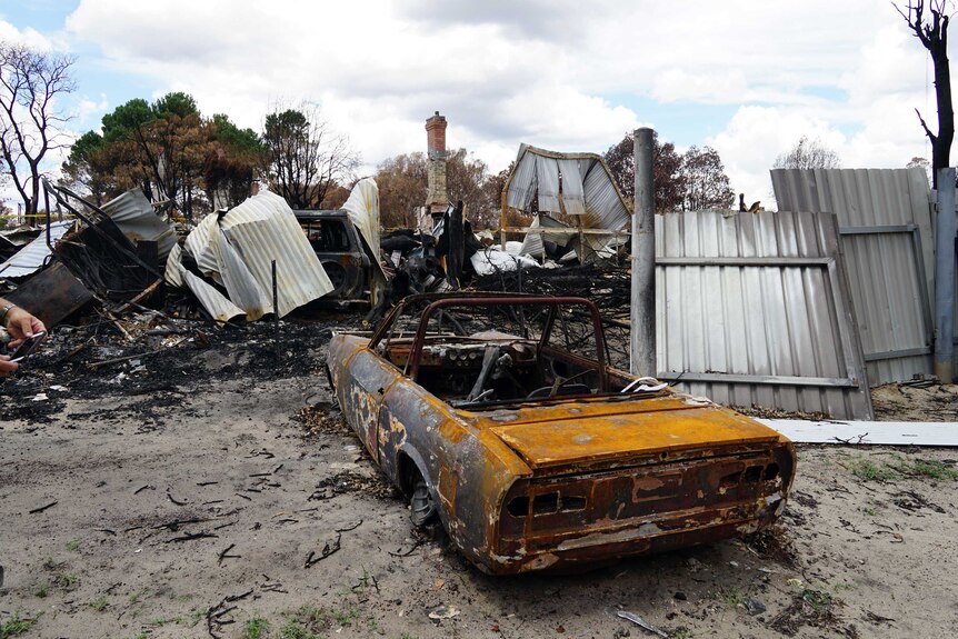 Burnt-out car and buildings in the bushfire devastated town of Yarloop.