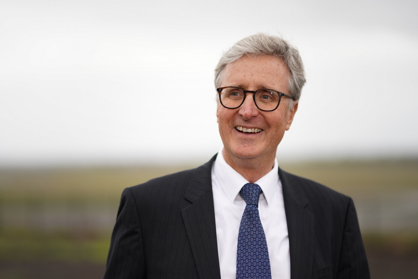 Simon Hickey con gafas y traje