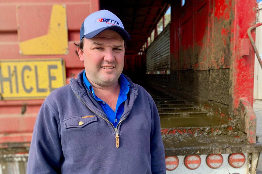 Chris Betts, freight company co-owner standing with truck full of excrement at wash station