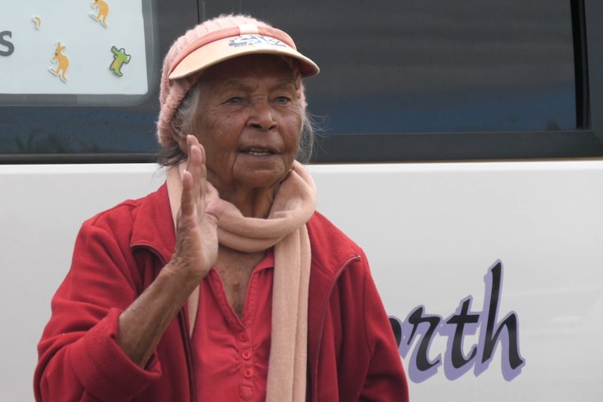 Elderly First Nations woman raising her hand