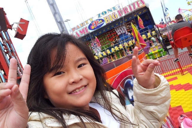 A girl throwing peace signs at a show