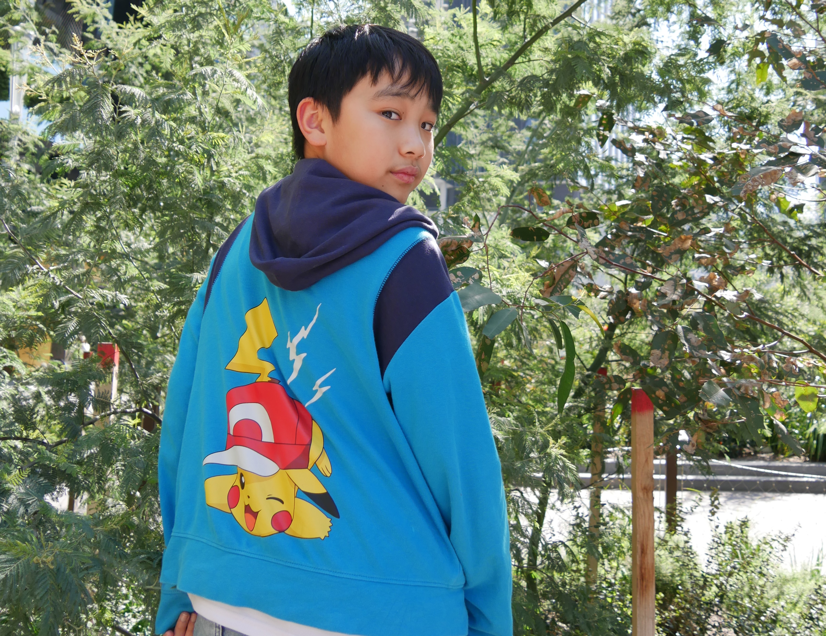 A boy in front of trees