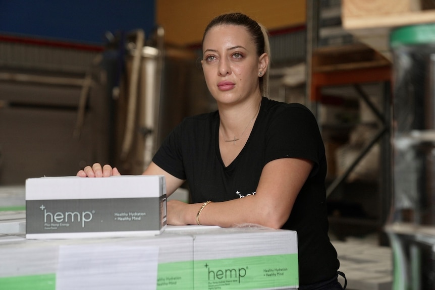 Natalie Beaini owner of Plus Hemp stands with a box of her product.