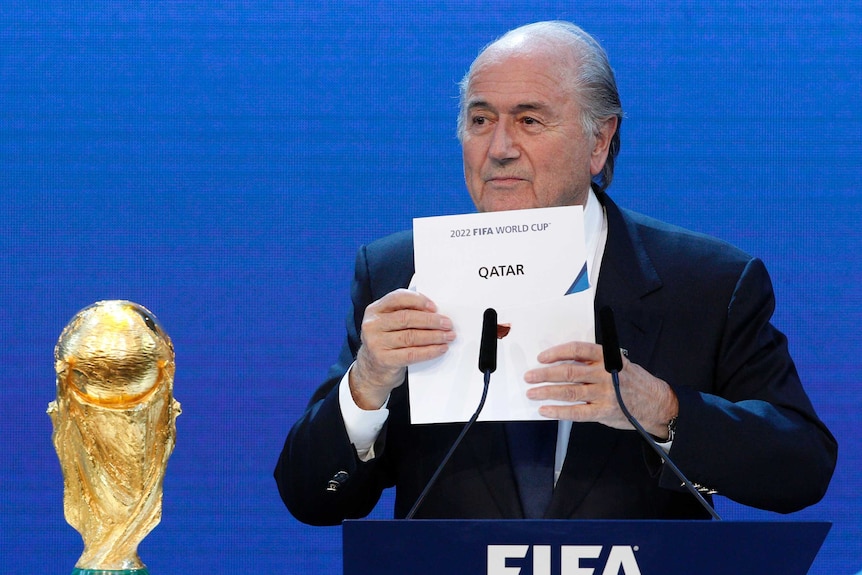 Sepp Blatter holds up a card saying Qatar 2022.