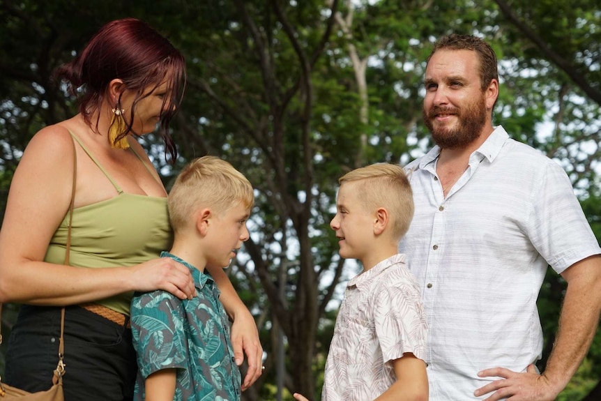 Emily and Sam Romeo stand in a park with their two young boys.