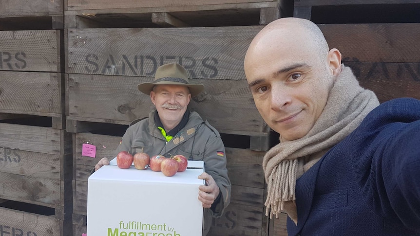 Apple producer Kevin Sanders holds up his apples standing next to Megafresh found Alex Stefan