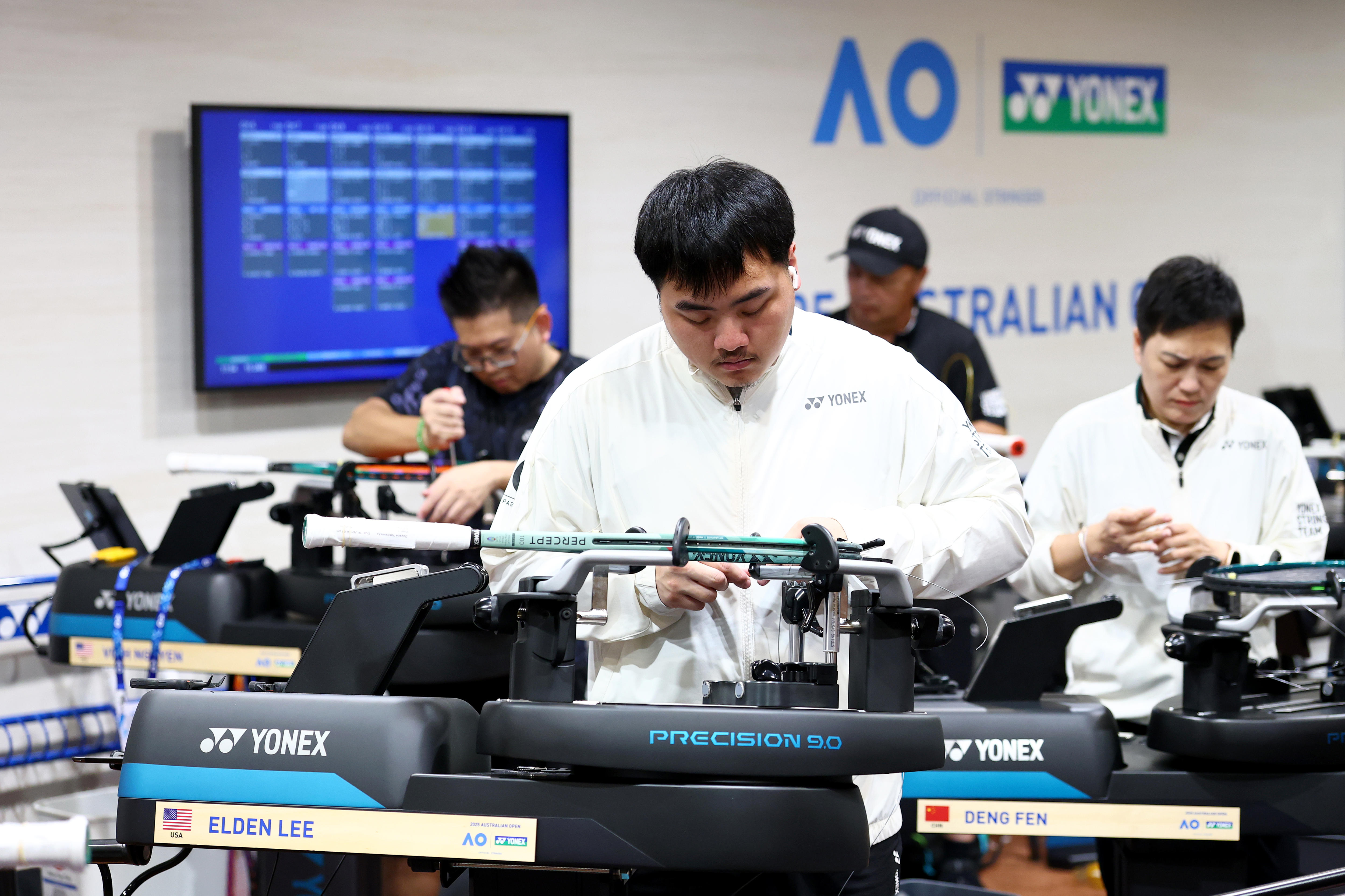 Um homem olha para baixo enquanto joga uma raquete de tênis.