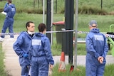 Police officers stand at crime scene